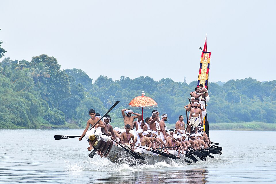 The Melukara Palliyodam gliding through the Pampa River to attend the Aranmula Valla Sadya — these sacred snake boats are distinct from other Chundan Vallam in their taller structure, Vedic symbolism, and status as direct embodiments of Lord Krishna, participating in Kerala's most ritually significant water procession during Onam.
