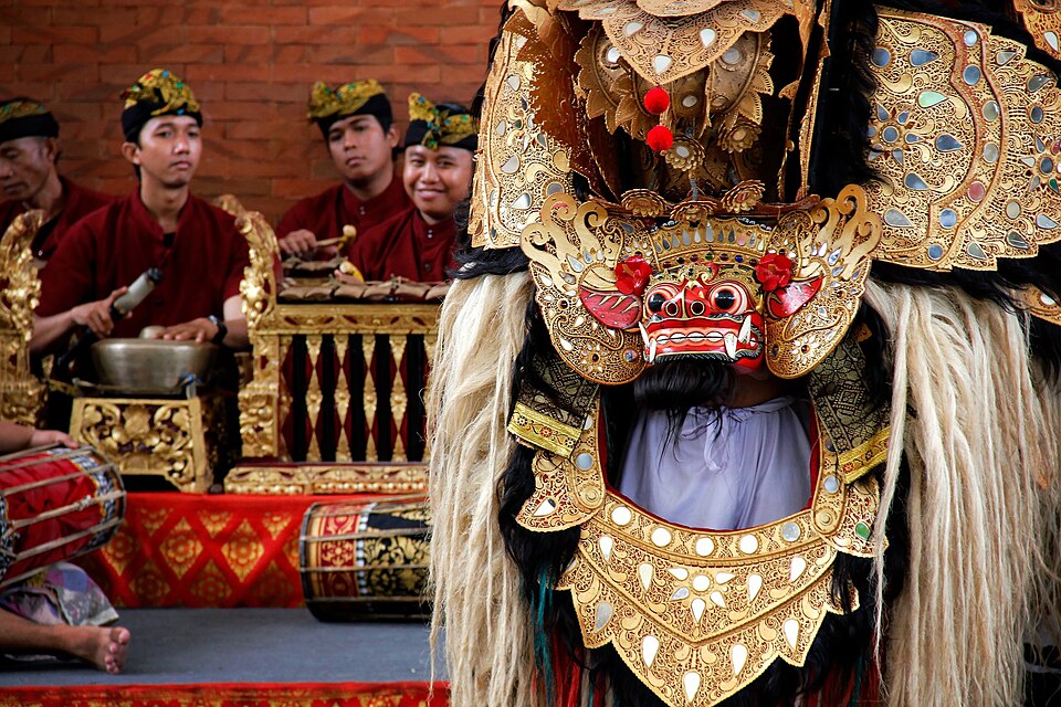Balinese Barong dance performed with live Gamelan music — the sacred lion-spirit Barong in performance alongside the Gamelan percussion orchestra, showing the integral relationship between the sacred costume-spirit and its musical invocation in Bali's most important ritual dance tradition, directly parallel to how the Chenda drum's specific rhythmic patterns summon and sustain the presence of deities in Kerala's Theyyam tradition