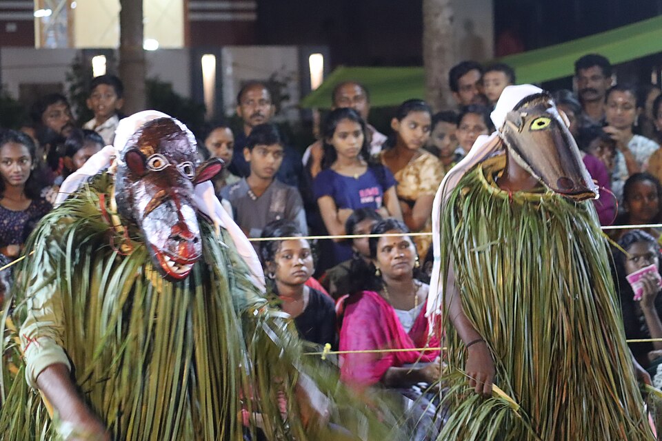 Karadikali competition at Kovoor, Kollam, Kerala — performers in bear costumes engaged in the traditional folk performance-game that combines energetic dance, competitive display, and community festival spirit in a form specific to Kollam and surrounding regions
